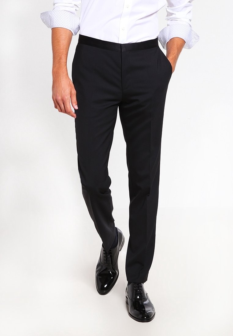 Zwarte op maat gemaakte broek met een gladde textuur, slim fit en zijzakken, gecombineerd met glanzende zwarte dresschoenen en een witte overhemd met knopen.