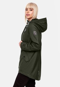 Green waterproof jacket with a hood, featuring a front zipper and button closure, elastic drawstring, and logo patch on the sleeve.