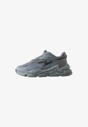 Grå atletisk sneakers med struktureret sål, mesh- og syntetisk overdel, snørelukning og sort zigzag detalje på siden, vist fra ydersiden.