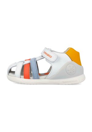 Sandalia blanca con detalles en naranja, azul y amarillo, correa ajustable y punta abierta, diseñada para niños.