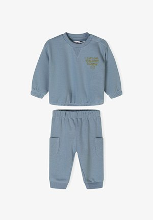 Ljusblå tröja och matchande byxor. Tröjan har ribbade ärmslut och en rundad halsringning, med broderad text. Byxorna har sidofickor.