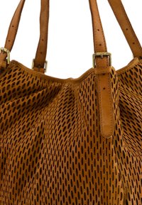 Bruine leren tote bag met geperforeerde textuur, voorzien van stevige hengsels en accenten van goudkleurig hardware. Rond ontwerp en ruime indeling.