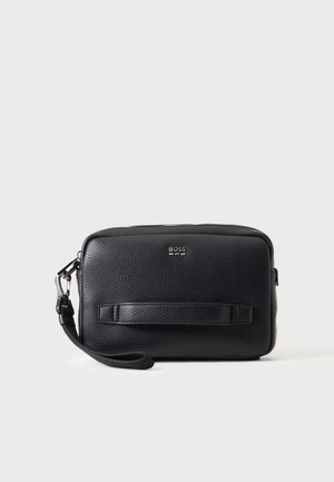 Petit sac bracelet en cuir noir texturé avec fermeture éclair, bande horizontale sur le devant, petit logo argenté "BOSS" et bracelet détachable sur le côté gauche.