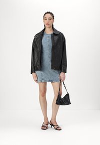 Casaco de couro preto, vestido de ganga, sandálias pretas com tiras e uma pequena bolsa preta. Design minimalista com formas e texturas estruturadas.