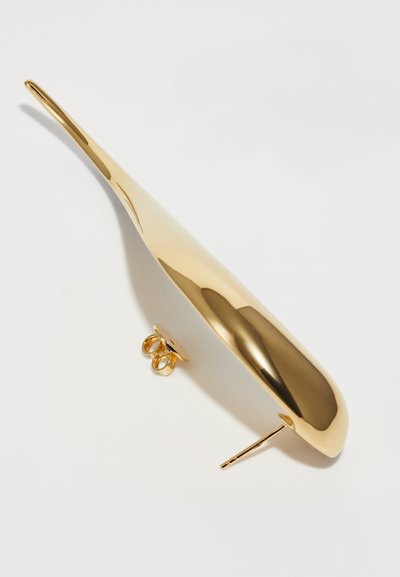 Pendiente de metal dorado con forma larga y curvada. Cuenta con un acabado pulido, un respaldo circular y un poste recto para una sujeción segura.