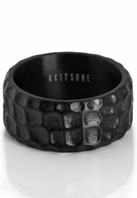 Schwarzer strukturierter Ring mit einem klobigen Design, das ein sechseckiges Muster aufweist. Innen graviert mit "AKITSUNE." Glatte, matte Oberfläche.