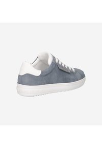 Zapatilla de ante gris con suela de goma blanca, puntera redonda, diseño estructurado y cierre de cordones. Presenta un acento de logo metálico en el lateral.