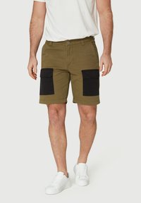 Pantalones cortos cargo en verde oliva con bolsillos frontales negros, hechos de una mezcla de algodón, con cierre de botón y corte recto.