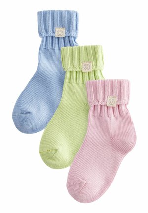 Drei Paare gestrickte Socken: blau, grün und pink. Jede hat einen gerippten Bund und ein kleines Etikett mit einem lächelnden Gesicht. Weicher Stoff, knielang.