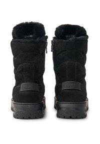 Zwarte enkellaarsjes van suède met een zachte voering van bont, voorzien van een ritssluiting en gestructureerde rubberen zolen. Logo geperst op de hiel.
