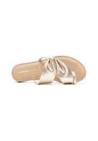 Sandalias planas metálicas doradas con un diseño anudado en la parte superior y una plantilla suave beige. Presentan tiras delgadas y detalles de costura.