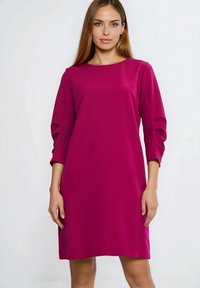 Różowa sukienka z okrągłym dekoltem i rękawami do połowy łokcia, z delikatnymi plisami na rękawach, wykonana z gładkiej tkaniny.