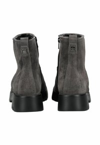Botas de tobillo de ante gris con suelas de goma negra, que cuentan con un cierre de cremallera y una textura suave. Diseño minimalista con un sutil detalle de logo.