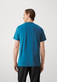 T-skjorte med korte ermer i livlig blå bomull, med rund hals og avslappet passform, myk tekstur og minimal detaljering.