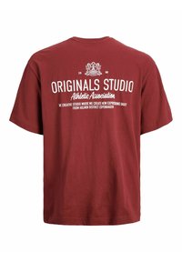 Maroons T-shirt med hvid tekst "Originals Studio Athletic Association" og "Det kreative studio, hvor vi skaber nye udtryk hver dag."