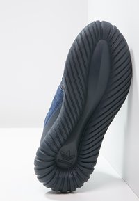 Sneaker blu navy con parte superiore in tessuto strutturato, suola in gomma e motivo rigato. Presenta il logo Adidas sulla suola.