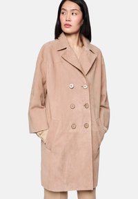 Doppelreihiger Mantel aus weichem, rosafarbenem Wildleder mit großen Knöpfen, Reverskragen mit Kerbe und Seitentaschen; lockere Passform mit langen Ärmeln.