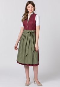 Traditional dress featuring a maroon polka dot bodice, white sleeves, and a green striped skirt with a bow at the waist.