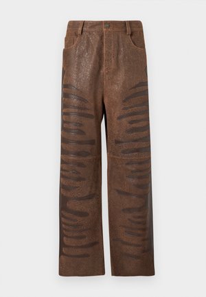 Bruine neplederen broek met een gestructureerde afwerking, voorzien van langwerpige horizontale uitsparingen langs de zijkanten en een rechte pijp.