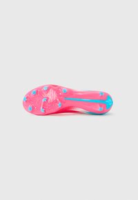 Suela de botín de fútbol en rosa brillante con tacos azules y un swoosh azul de Nike, vista desde la parte inferior sobre un fondo blanco.