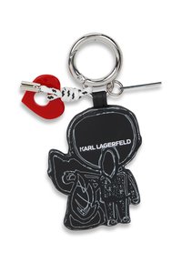 Portachiavi con una figura in gomma nera con contorno bianco, testo "Karl Lagerfeld", un ciondolo a forma di cuore rosso e un attacco ad anello argentato.