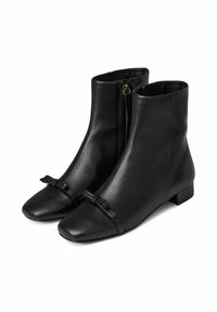Botas de tobillo de cuero negro con puntera cuadrada, tacón plano, cremallera lateral y detalle de lazo en la parte delantera. Textura suave en toda la superficie.