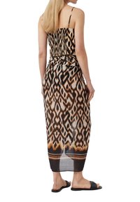 Maxikleid aus leichtem Stoff mit einem geometrischen Muster in Braun und Schwarz, einem taillierten Oberteil, verstellbaren Trägern und einem schwingenden Rock.