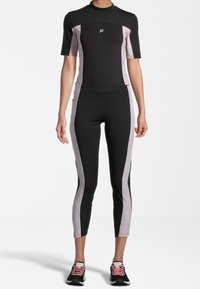 Černý a růžový aktivní set oblečení obsahující tričko s krátkým rukávem a přiléhavé kalhoty s vysokým pasem, vyrobené z pružného materiálu. Jemné značkování je zahrnuto.