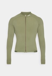 Veste de cyclisme à manches longues vert olive, en tissu léger, fermeture éclair sur toute la longueur à l'avant, col haut, design ajusté, logo discret sur l'épaule, texture lisse.