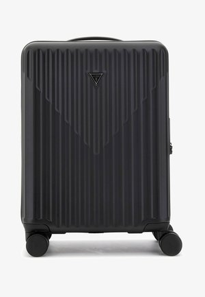 Hard-shell suitcase in black, featuring vertical ridges, a triangular brand emblem, and four multi-directional wheels for mobility.