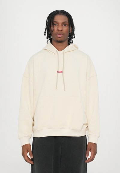 Cream-colored hoodie with a kangaroo pocket, drawstring hood, and a small red logo on the chest. Made from soft fabric, relaxed fit.