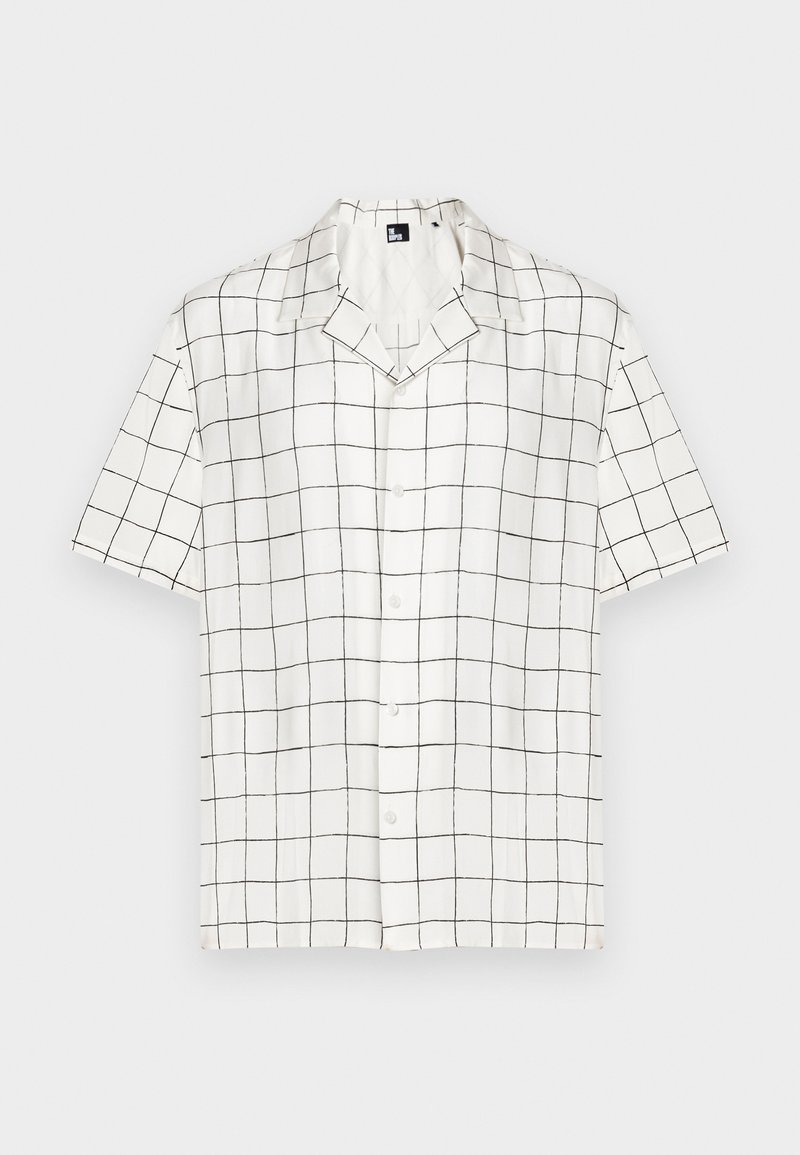Kortärmad skjorta med krage i vit tyg med ett svart rutmönster, med knappar framtill och avslappnad passform.