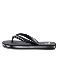 Mustat sandaalit, joissa on kuvioitu kumipohja, ohut hihna ja valkoiset yksityiskohdat reunoilla. "Quiksilver"-logo näkyvissä hihnassa.
