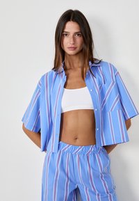 Blau gestreiftes Kurzarmhemd mit rosa und weißen Linien, ausgestattet mit einer durchgehenden Knopfleiste und einer Brusttasche, kombiniert mit passender Hose mit elastischem Bund.