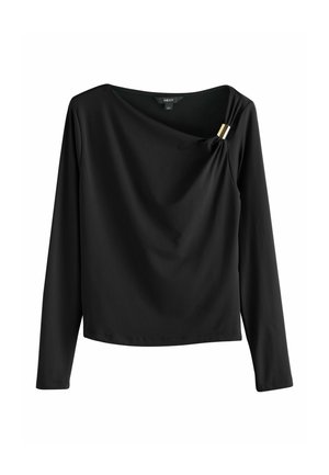 Black long-sleeve top with a draped design, featuring a gold accent pin at the shoulder. Smooth texture and slightly relaxed fit.