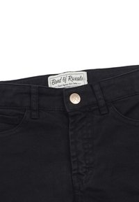 Svarta jeans i denim med resårmidja, metallknappsstängning och synlig sömnad. Har en vävd etikett med texten "Band of Rascals."