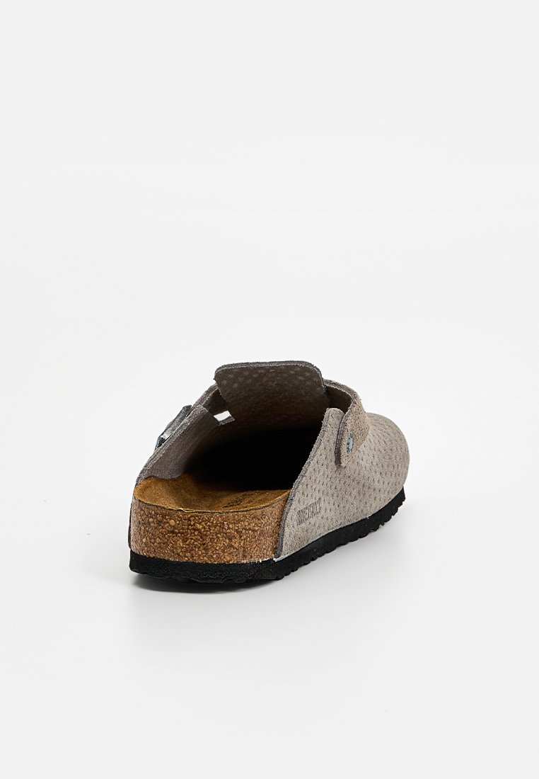 Grauer perforierter Slipper mit einem Korkfußbett, robuster schwarzer Gummisohle und verstellbarem Schnallen-Detail am Rückengurt.