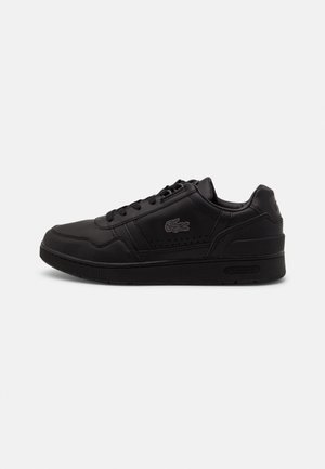Sneaker in pelle nera con design a lacci, dettagli perforati sui lati e suola in gomma testurizzata. Presenta un logo discreto vicino al tallone.