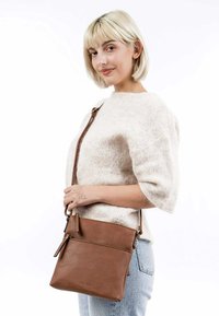 Borsa a tracolla in pelle marrone con due tasche con zip, texture liscia, tracolla regolabile e design minimalista.