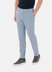 Vaaleansiniset räätälöidyt housut teksturoidusta kankaasta, joissa on klassinen leikkaus, sivutaskut, ja harmaiden lenkkitossujen kanssa yhdistettynä.