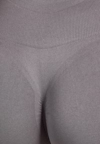 Leggings grigi a vita alta con texture a coste. Presentano una finitura liscia e un design aderente che offre una vestibilità avvolgente sulla silhouette.