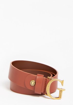 Bruine leren riem opgerold, met een goudkleurige "G" gesp met "GUESS" gegraveerd aan de zijkant.