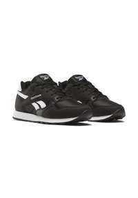 Black athletic sneakers with a smooth fabric upper, white accents on the sides, and a padded collar. Features a textured rubber sole.