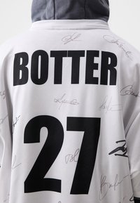 White sports jersey featuring black text "BOTTER" and "27," with multiple light gray signatures scattered across the fabric.