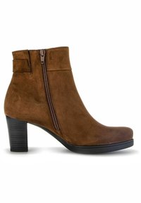 Bottines en suède marron avec une fermeture éclair sur le côté, un talon épais, un bout arrondi et des détails de couture subtils. Elles sont dotées d'une semelle noire lisse.