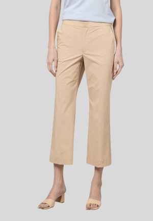 Pantaloni cropped beige in misto cotone con frontale piatto, tasche laterali e taglio dritto, abbinati a décolleté chiare aperte davanti.