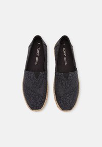 Zwarte stoffen instapschoenen met een bloemenpatroon, elastische zij-inserts en jute zolen. Voorzien van een zacht binnenvoering met logo-merk.