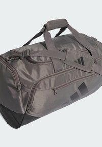 Borsa da viaggio grigia in tessuto resistente, dotata di doppi manici, tracolle regolabili, tasche con cerniera e una sezione inferiore nera.