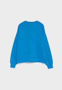 Sudadera azul con corte holgado, mangas largas, cuello redondo y puños acanalados. Fabricada con un tejido suave y de textura lisa.