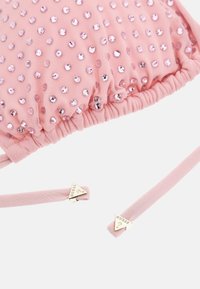 Pink fabric bag with all-over pink sequins, gathered top design, and smooth straps featuring gold-tone hardware with brand logo.